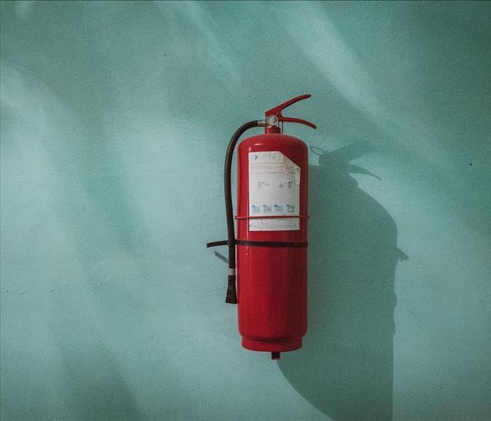 red fire extinguisher on blue wall